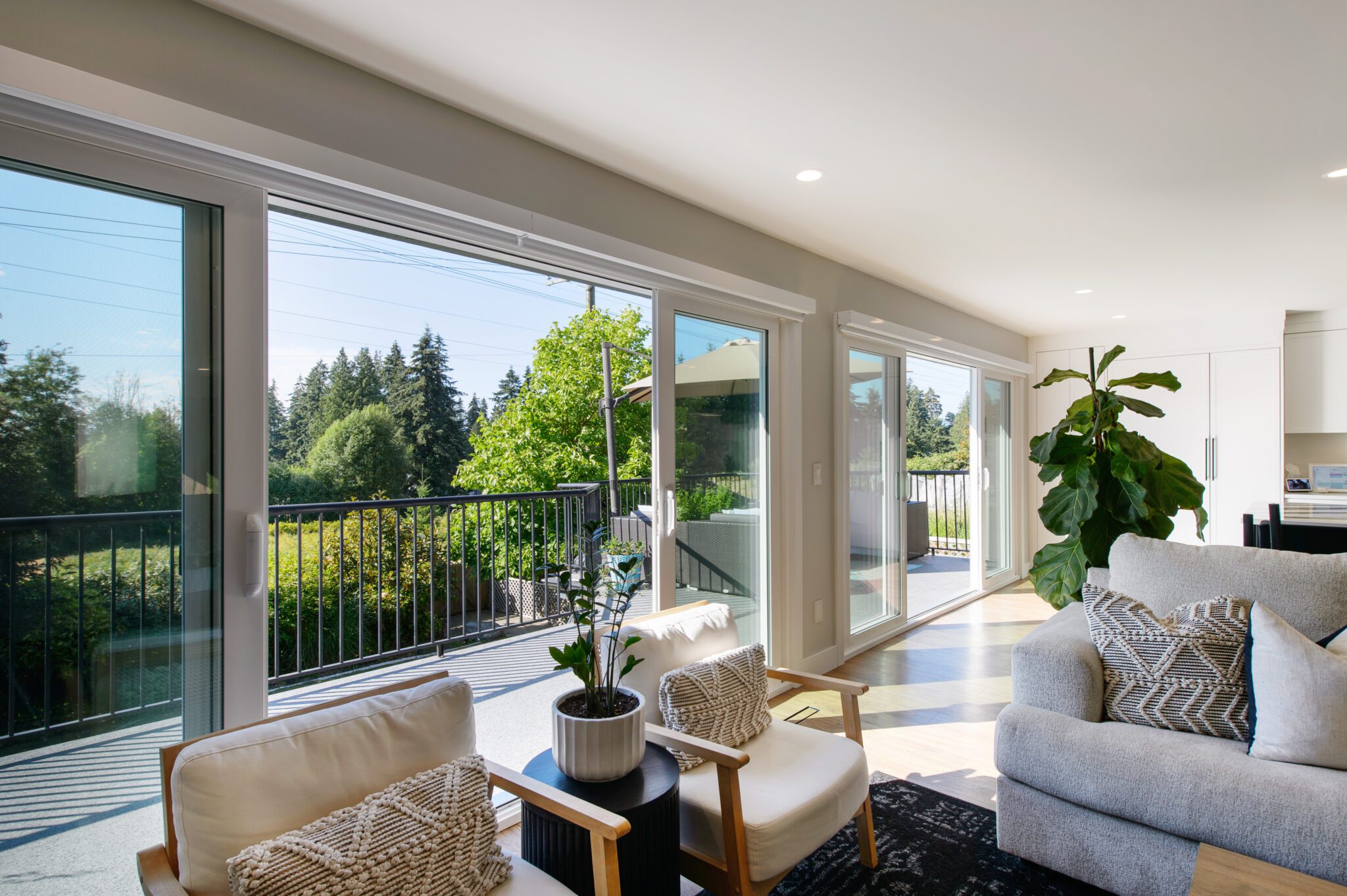 Living room with couches in foreground and a view of the deck through open sliding doors