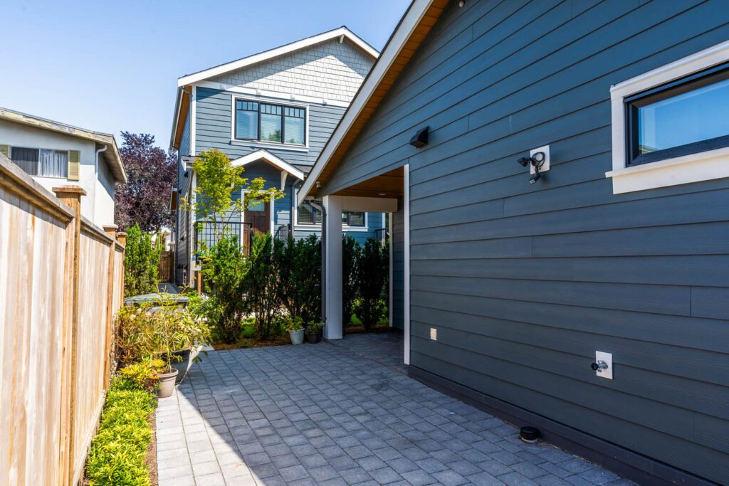 Side photo of laneway home with navy blue paneling. 